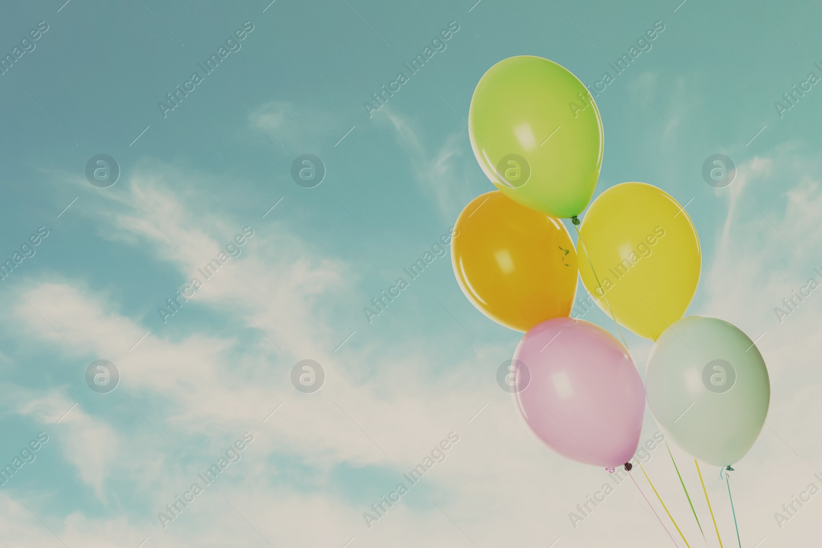 Image of Colorful balloons flying in blue sky. Space for text