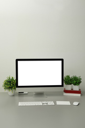 Photo of Modern workplace with computer and houseplants. Interior design