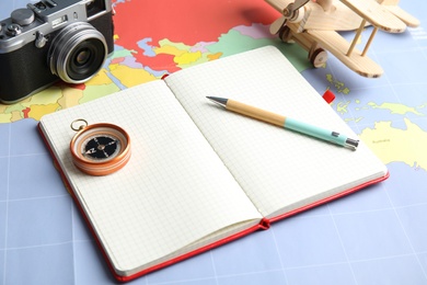 Photo of Composition with notebook and camera on world map, space for text. Travel agency