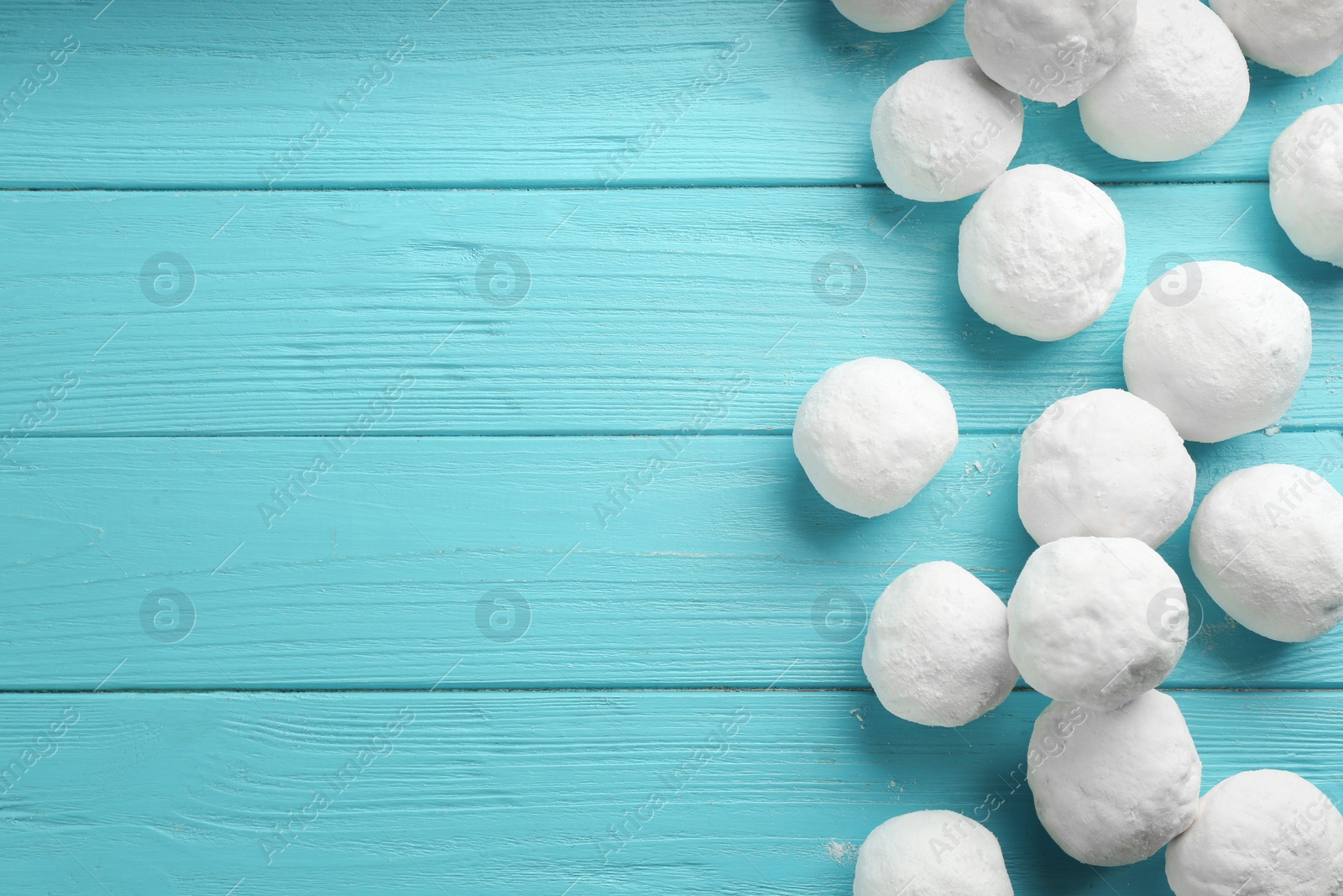 Photo of Snowballs on light blue wooden background, flat lay. Space for text