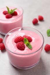 Delicious raspberry mousse with mint on light grey table