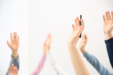 People raising hands to ask questions at business training on white background, closeup