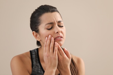 Photo of Young woman with sensitive teeth on color background. Space for text