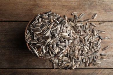 Raw sunflower seeds on wooden table, flat lay