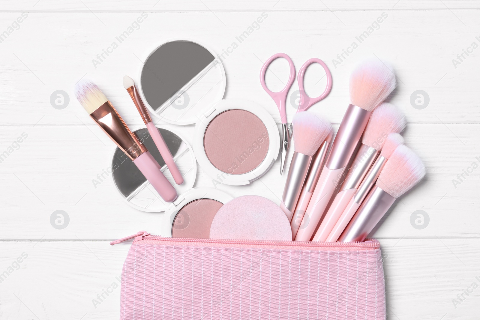 Photo of Cosmetic bag with makeup products and beauty accessories on white wooden background