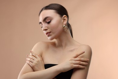 Photo of Portrait of beautiful young woman on beige background