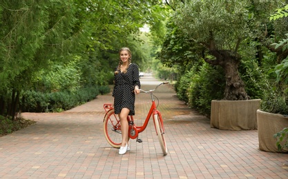 Photo of Beautiful woman in casual outfit with bicycle outdoors