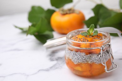 Photo of Delicious dessert with persimmon and chia seeds on table. Space for text