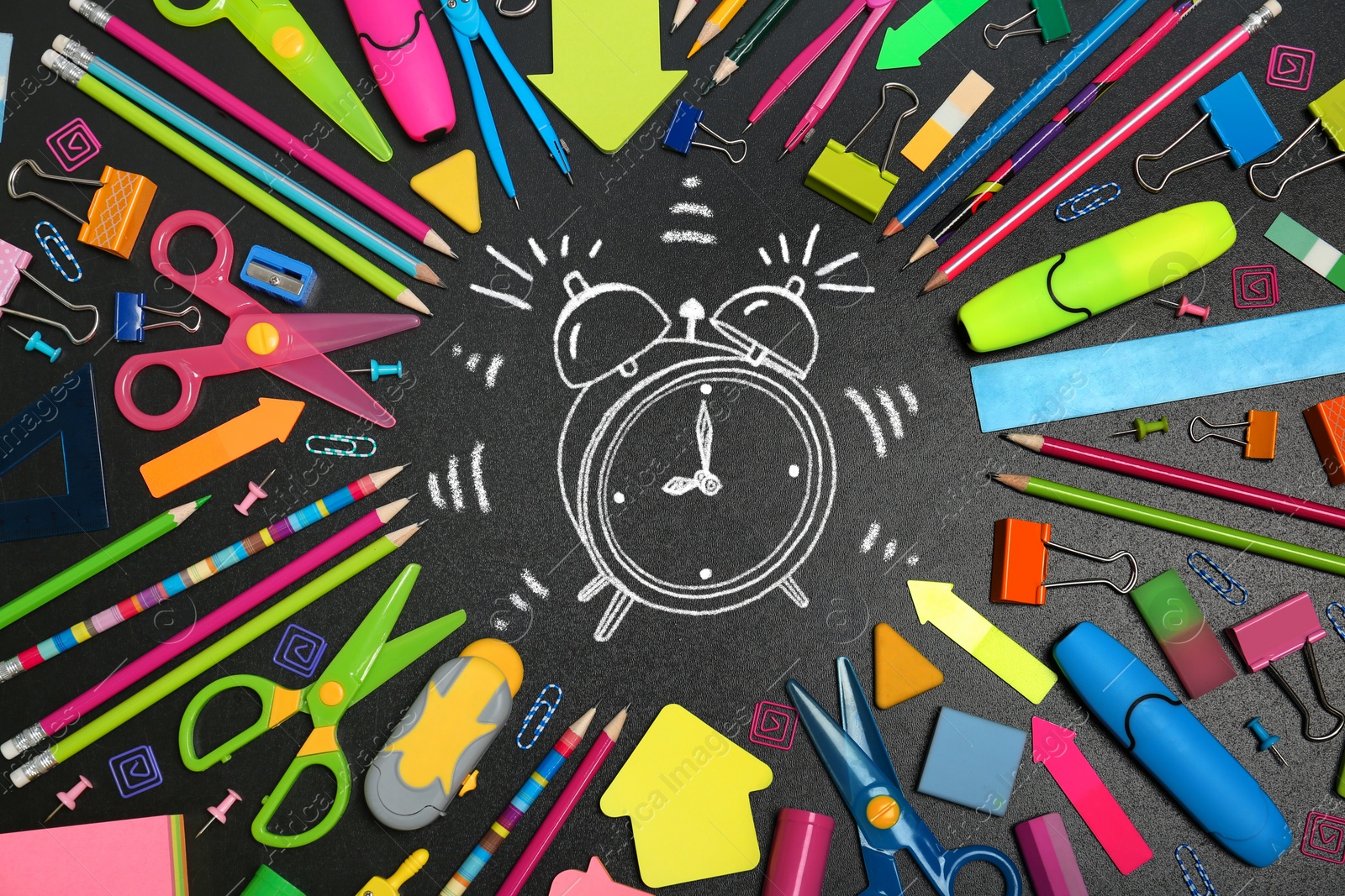 Image of Different stationery and drawn alarm clock on blackboard surface, flat lay. Time to school