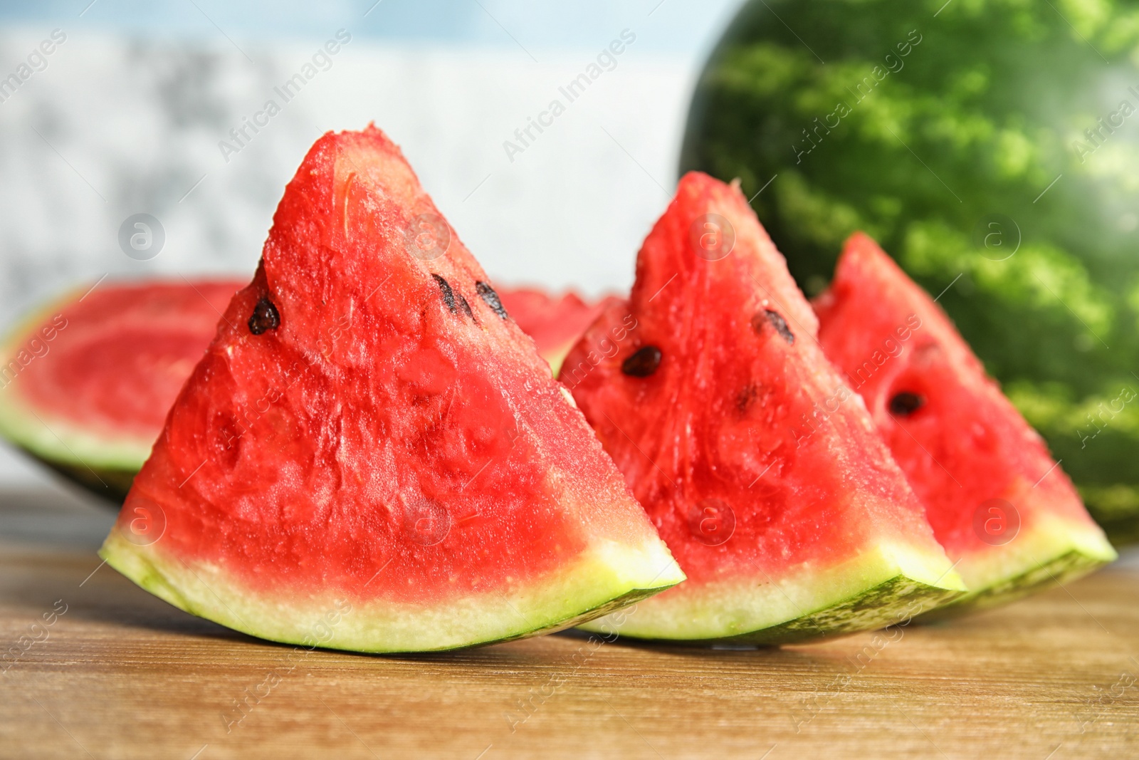 Photo of Fresh juicy watermelon slices on wooden table