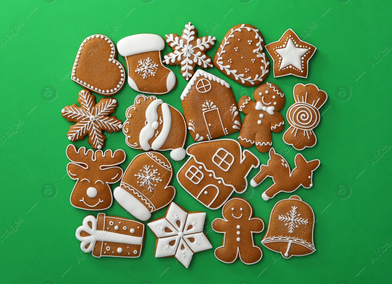 Photo of Different Christmas gingerbread cookies on green background, flat lay