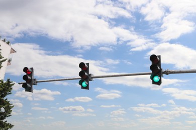 Modern traffic lights in city against cloudy sky