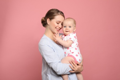 Photo of Portrait of happy mother with her baby on color background