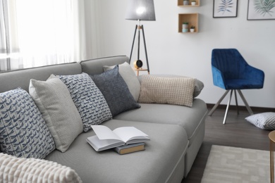 Photo of Elegant living room with comfortable sofa and armchair near window. Interior design