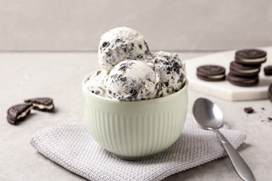 Photo of Bowl with ice cream and crumbled chocolate cookies on table