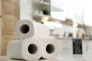 Rolls of paper towels on table in kitchen, space for text