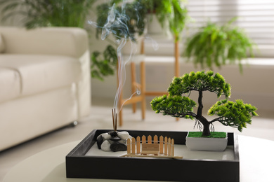 Photo of Beautiful miniature zen garden with incense sticks on table indoors
