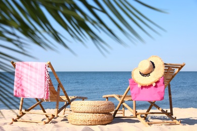 Photo of Wooden sunbeds and beach accessories on sandy shore