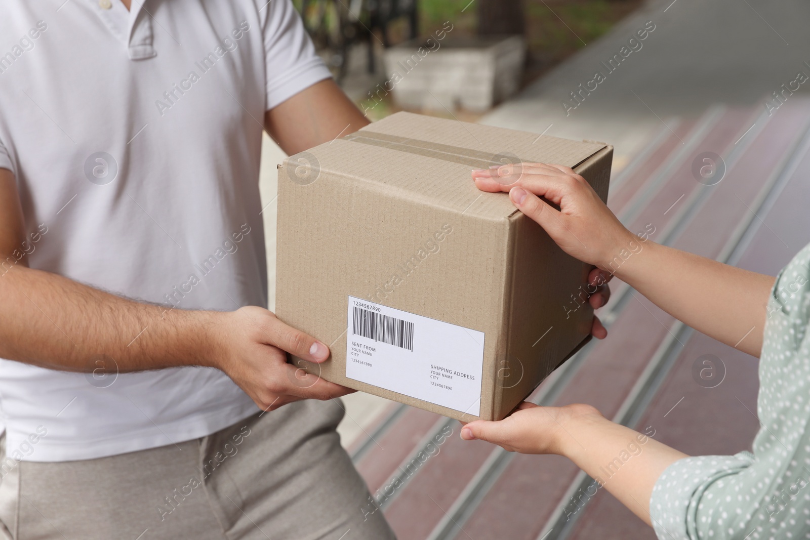 Photo of Woman receiving parcel from courier outdoors, closeup