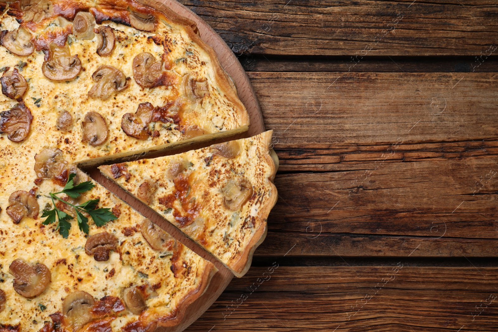 Photo of Delicious pie with mushrooms and cheese on brown wooden table, top view. Space for text