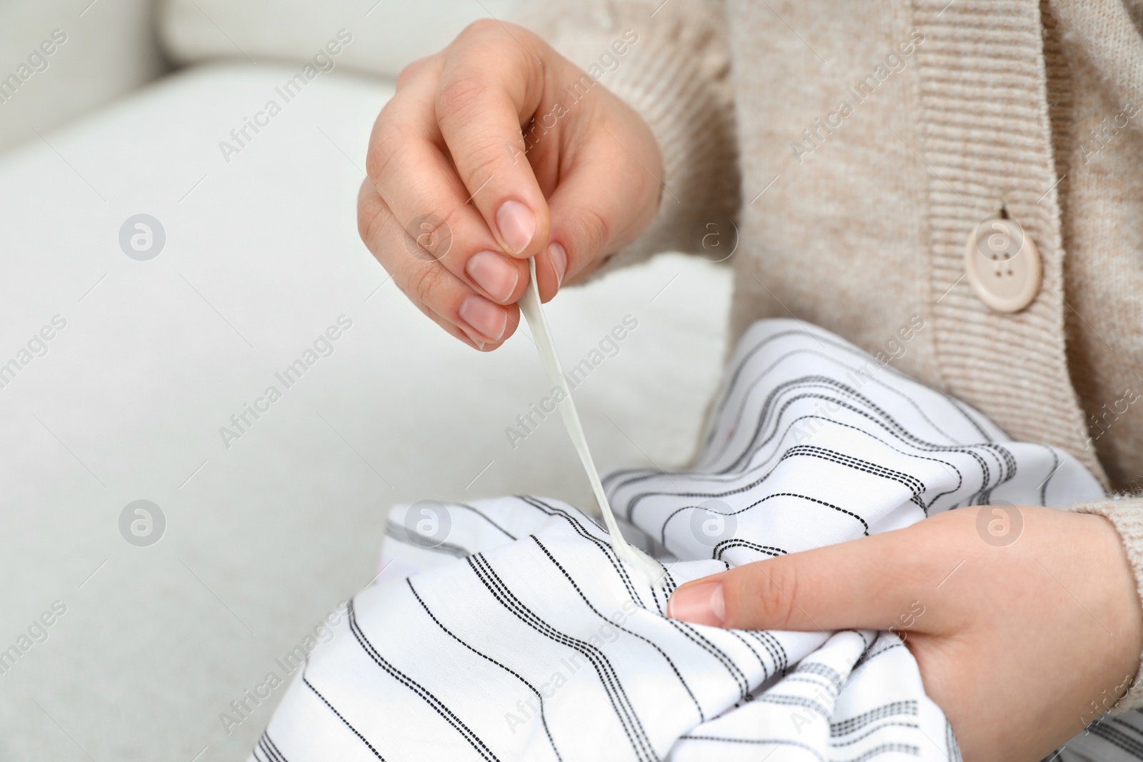 Photo of Woman removing chewing gum from shirt, closeup