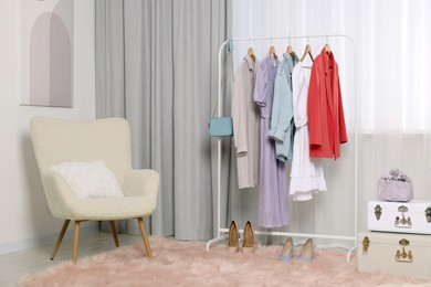Clothing rack with stylish women's clothes on hangers in boutique