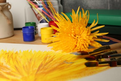 Photo of Painting of chrysanthemum on canvas, flower, colorful paints and brushes, closeup