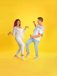 Photo of Beautiful lovely couple dancing on yellow background