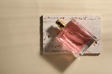 Photo of Luxury women's perfume in bottle on beige background, top view