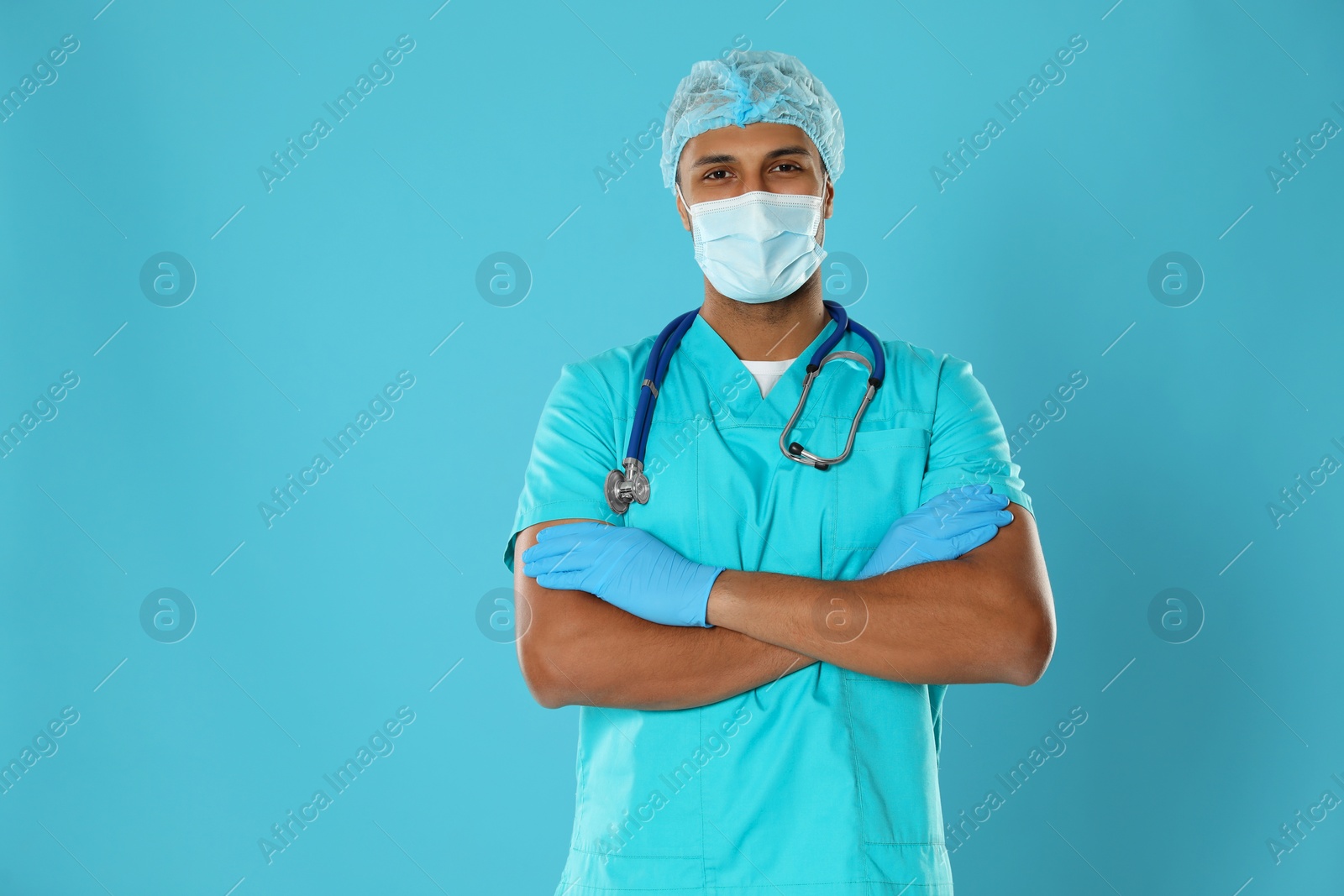 Photo of Doctor or medical assistant (male nurse) with protective mask and stethoscope on turquoise background. Space for text