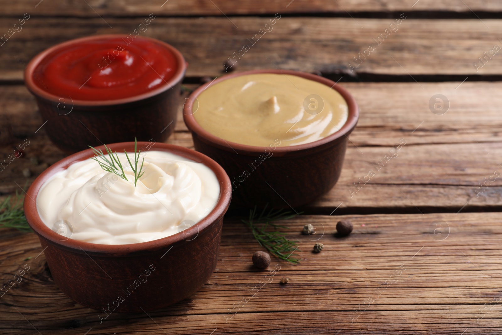 Photo of Many different sauces on wooden table, space for text