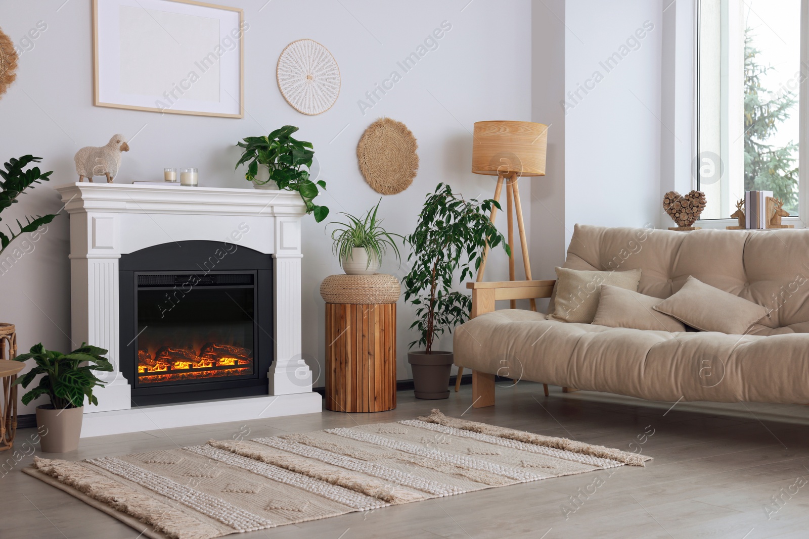 Photo of Beautiful living room interior with fireplace, green houseplants and comfortable sofa