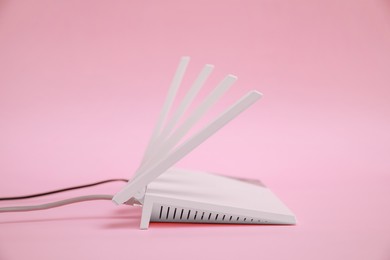 Photo of One modern Wi-Fi router on pink background