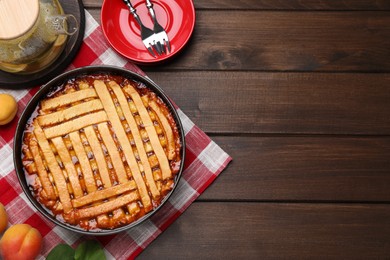 Photo of Delicious apricot pie in baking dish on wooden table, flat lay. Space for text