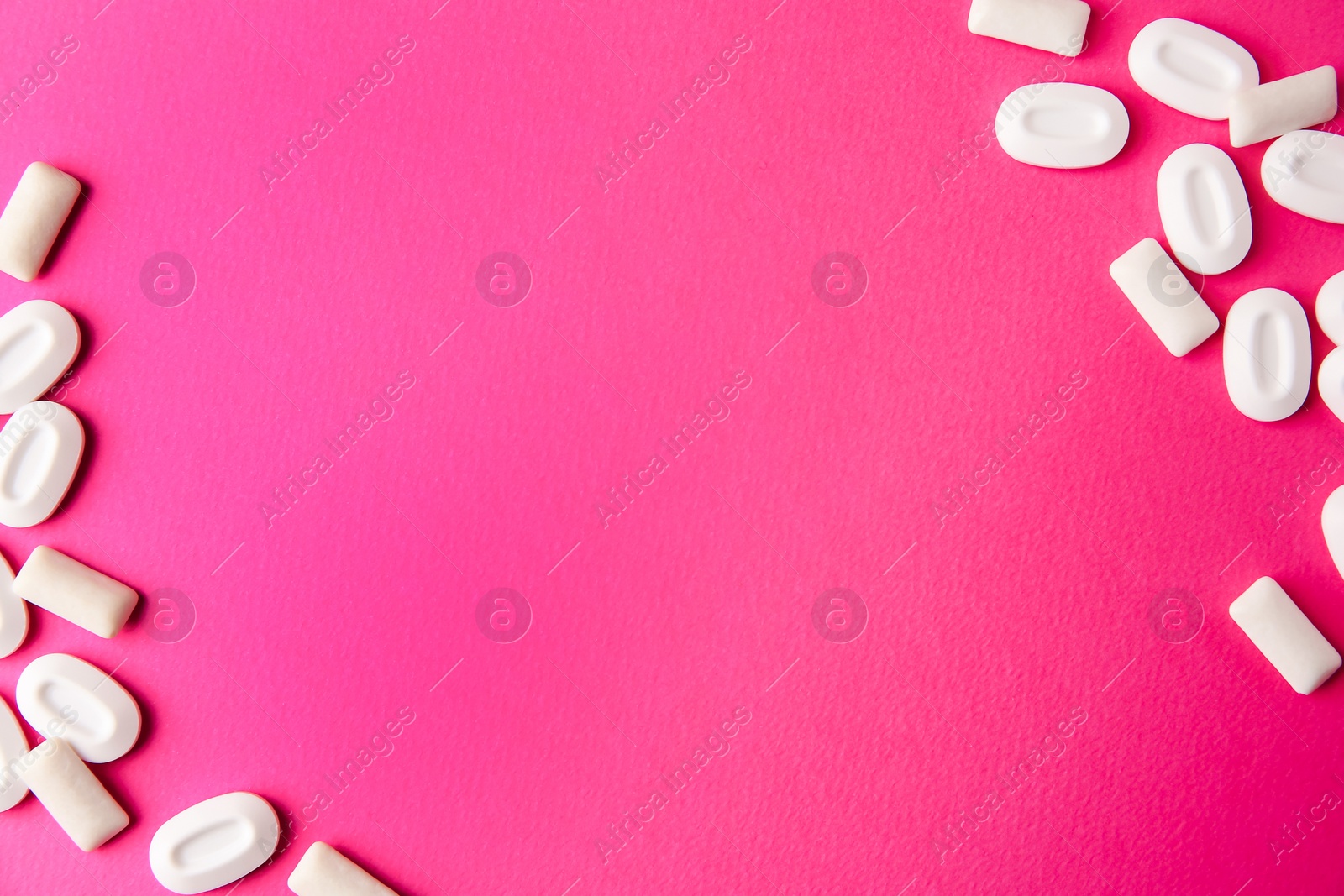 Photo of Many different chewing gums on pink background, flat lay. Space for text