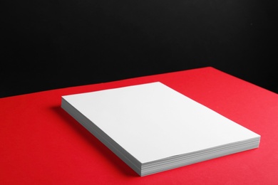 Photo of Empty stack of papers on color background. Mockup for design