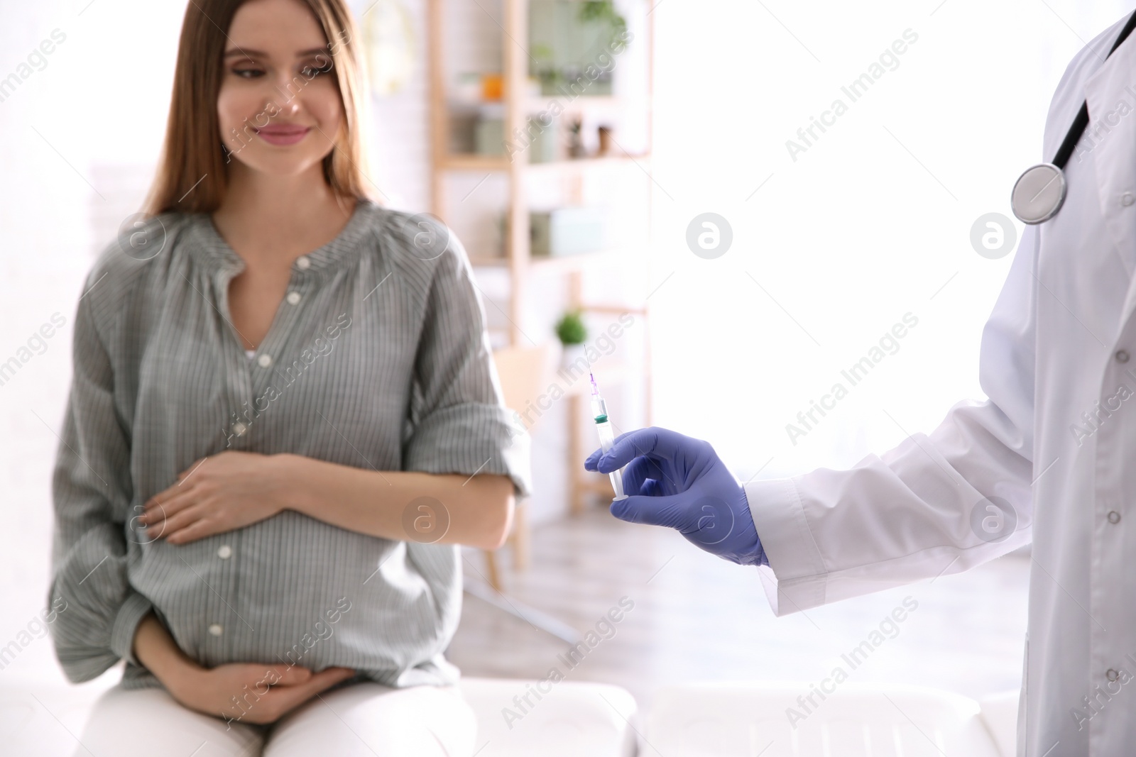 Photo of Doctor giving injection to pregnant woman in hospital. Vaccination concept