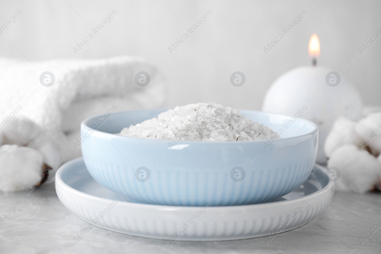 Photo of White sea salt for spa scrubbing procedure on grey marble table
