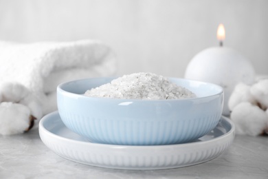 White sea salt for spa scrubbing procedure on grey marble table