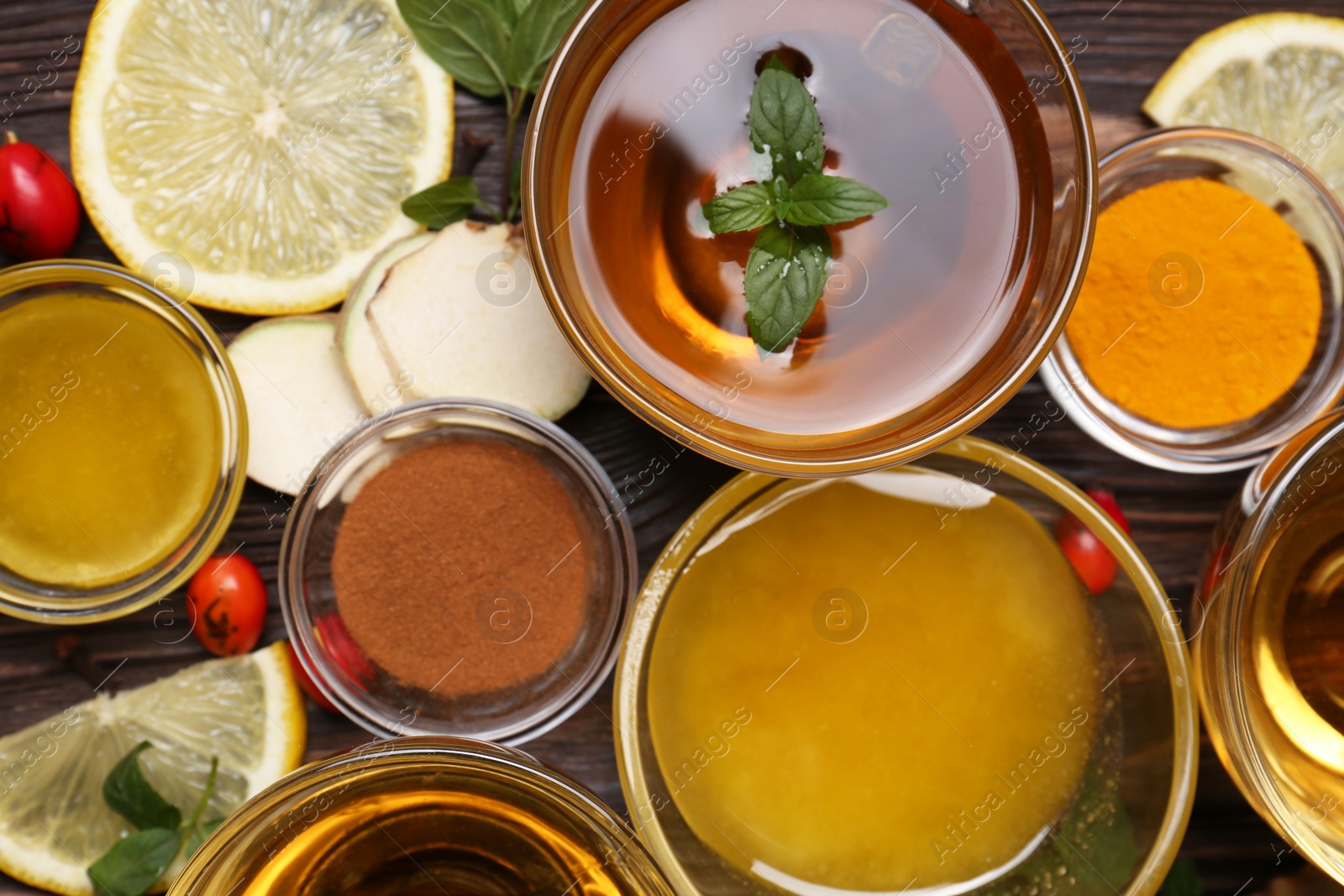 Photo of Flat lay composition of tea with honey and ingredients on wooden table