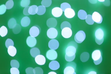 Photo of Blurred view of beautiful lights on green background