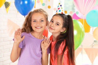 Happy children in room decorated for birthday party