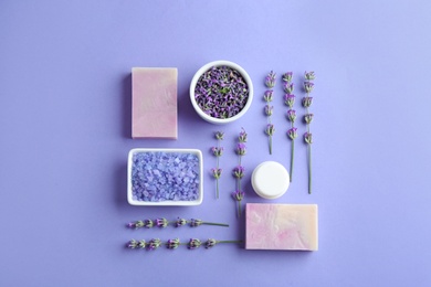 Photo of Flat lay composition with hand made soap bars and lavender flowers on violet background