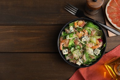 Photo of Delicious pomelo salad with shrimps served on wooden table, flat lay. Space for text