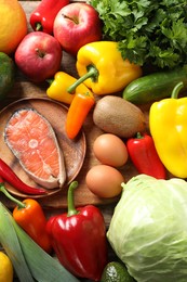 Photo of Healthy meal. Different vegetables and raw salmon on wooden table, flat lay