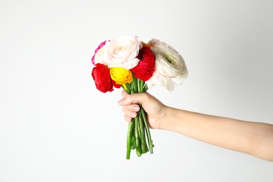 Woman holding bouquet with beautiful ranunculus flowers on white background