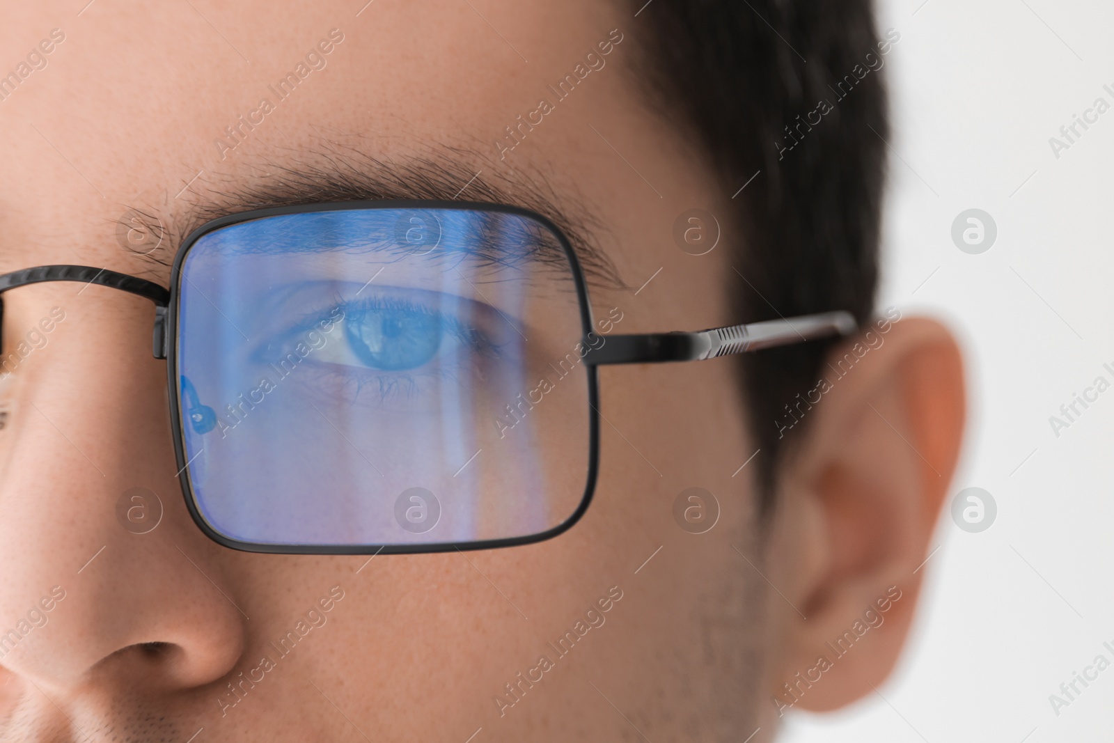 Photo of Man wearing glasses on light background, closeup