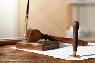 Photo of Notary contract. Wax stamp, document and gavel on wooden table