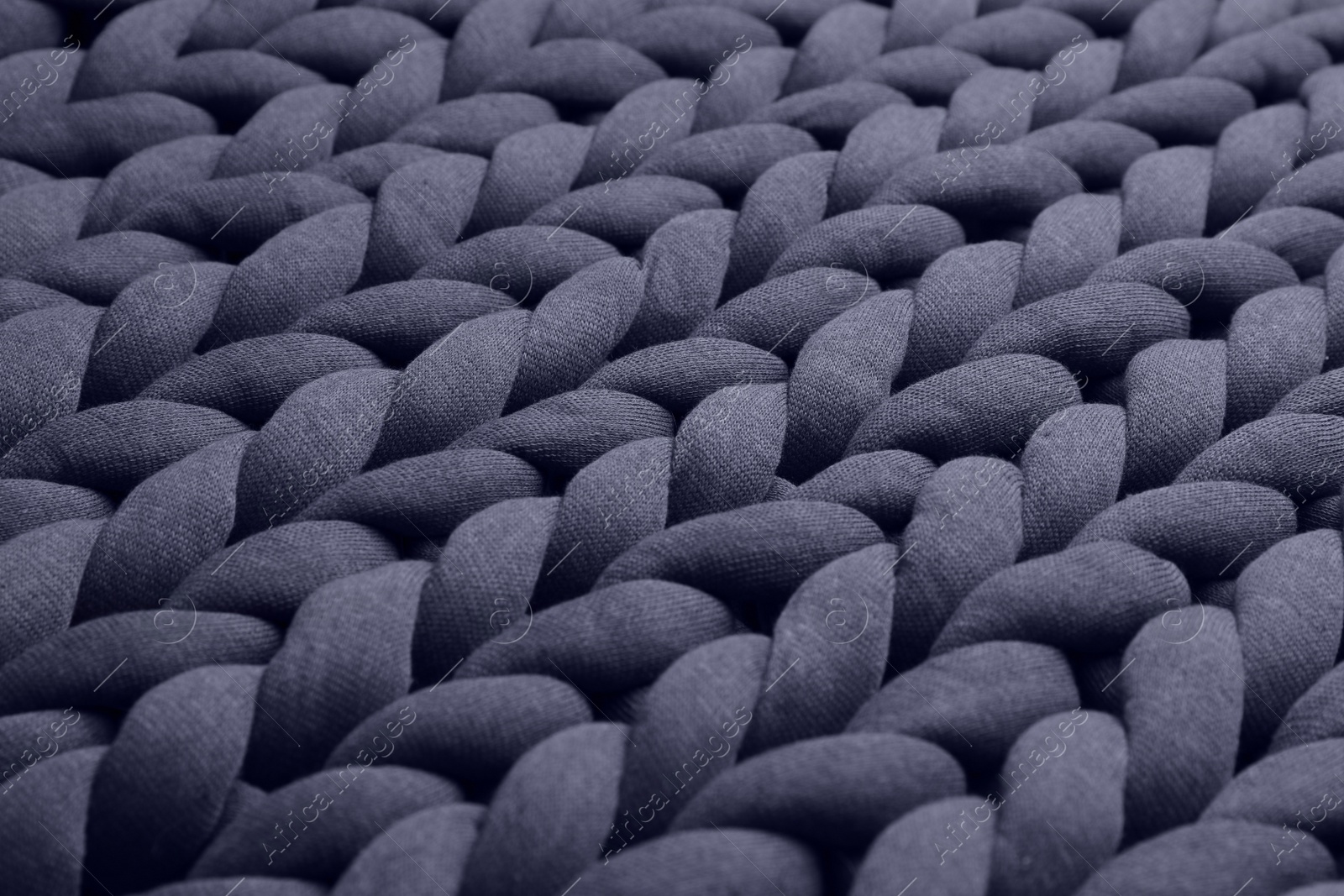 Photo of Closeup view of grey chunky knit blanket as background