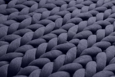 Closeup view of grey chunky knit blanket as background